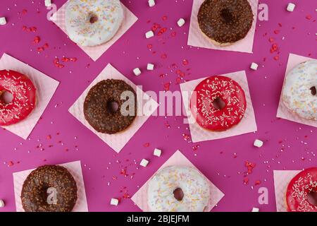 Glasierte Donuts auf farbigem Hintergrund Stockfoto