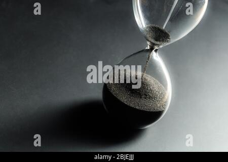 Sanduhr auf dunklem Hintergrund. Makrofoto. Nahaufnahme. Stockfoto