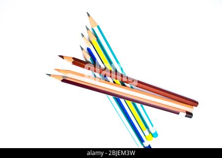 Sieben verschiedene Buntstifte aus Holz, übereinander auf weißem Hintergrund angeordnet Stockfoto