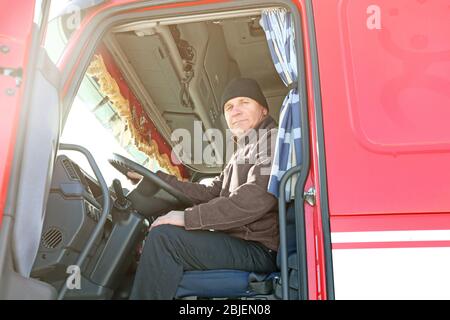 Ältere Fahrer sitzt in der Kabine von großen modernen LKW Stockfoto
