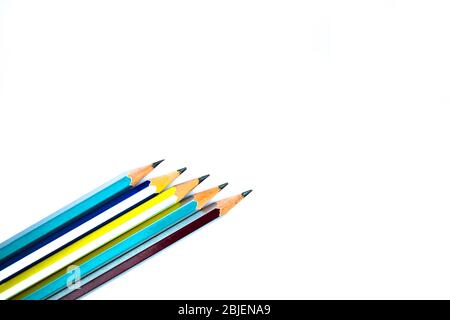 Einige verschiedene farbige Bleistiftstifte aus Holz auf weißem Papier angeordnet Stockfoto