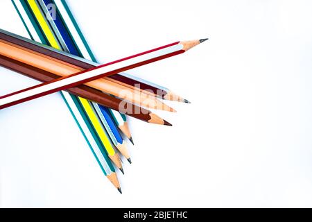 Acht verschiedene Buntstifte aus Holz übereinander auf weißem Hintergrund angeordnet Stockfoto