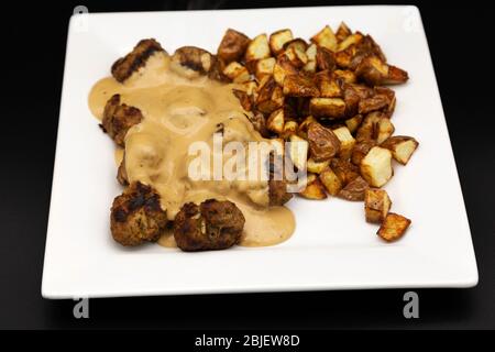 Ein Teller mit hausgemachten schwedischen Stil Fleischbällchen (Svenska Kottbullar) und cremige Sauce nach dem Rezept von Ikea veröffentlicht gemacht. Stockfoto