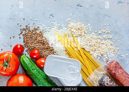 Lebensmittel-Set von Produkten. Lebensmittelspende auf blauem Hintergrund. Lebensmittelsammlung während einer Pandemie (Epidemie), sichere Lieferung von Lebensmitteln. Stockfoto