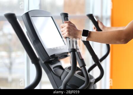 Junge Frau mit Fitness-Tracker-Training im Fitnessstudio Stockfoto