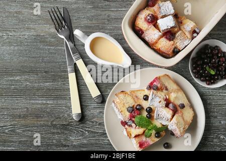 Teller mit Stücken gebackenem Brotpudding auf Holztisch Stockfoto