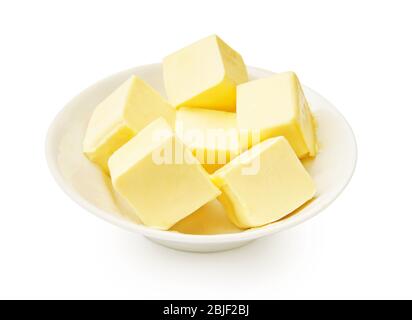 Butterstücke in weißer Schüssel isoliert. Butterwürfel. Stockfoto