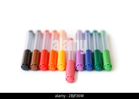 Nahaufnahme eines Sets von bunten, regenbogenfarbenen Markierstiften in einer Reihe, in der Ansicht „Low Angle“. Rosa Marker in der Mitte ist auseinander. Konzept der Aufsticht. Stockfoto