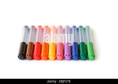 Nahaufnahme eines Sets von farbigen, regenbogenfarbenen Markern in einer Reihe, aus einem tiefen Winkel. Isoliert auf weißem Hintergrund mit Beschneidungspfad. Stockfoto