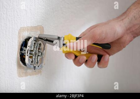 Hände des Elektrikers Installation der Steckdose, Nahaufnahme Stockfoto