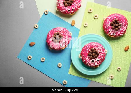 Lustig dekorierte Donuts auf dem Tisch Stockfoto