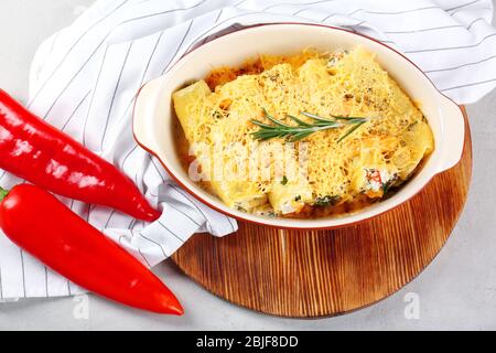 Köstliche gefüllte Cannelloni in Backform auf dem Tisch Stockfoto