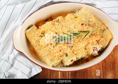 Köstliche gefüllte Cannelloni in Backform auf dem Tisch Stockfoto