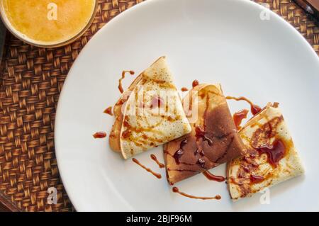 Selektiver Fokus. Leckeres Frühstück mit Pfannkuchen und Orangensaft auf Holztablett Stockfoto