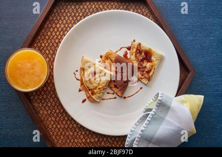 Selektiver Fokus. Leckeres Frühstück mit Pfannkuchen und Orangensaft auf Holztablett Stockfoto