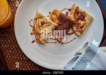 Selektiver Fokus. Leckeres Frühstück mit Pfannkuchen und Orangensaft auf Holztablett Stockfoto