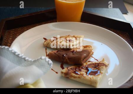 Selektiver Fokus. Leckeres Frühstück mit Pfannkuchen und Orangensaft auf Holztablett Stockfoto