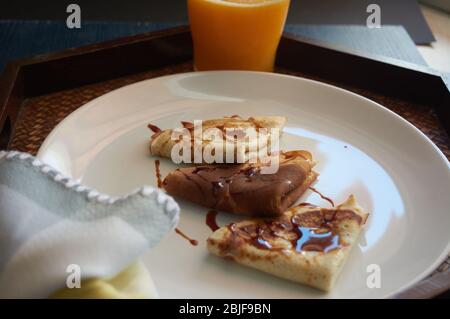 Selektiver Fokus. Leckeres Frühstück mit Pfannkuchen und Orangensaft auf Holztablett Stockfoto