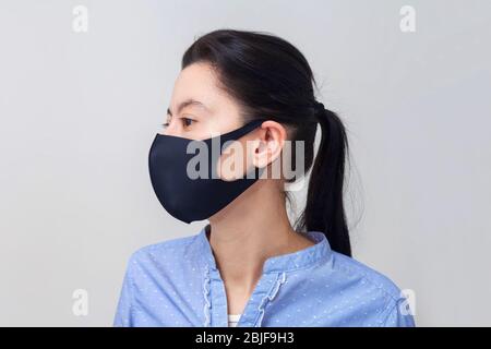 Mädchen in einer schützenden medizinischen Maske. Prävention von Viruserkrankungen der Erkältung und Grippe. Hellgrauer Hintergrund. In einer Atemmaske. Stockfoto