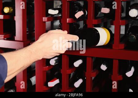 Männlicher Sommelier, der Wein im Keller auswählt Stockfoto