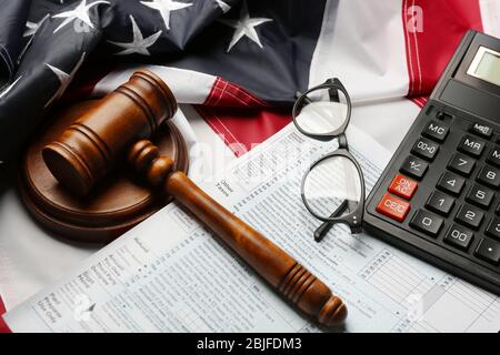 Richter Gavel, Taschenrechner, Brillen und Steuerformulare auf amerikanischer Flagge Hintergrund Stockfoto
