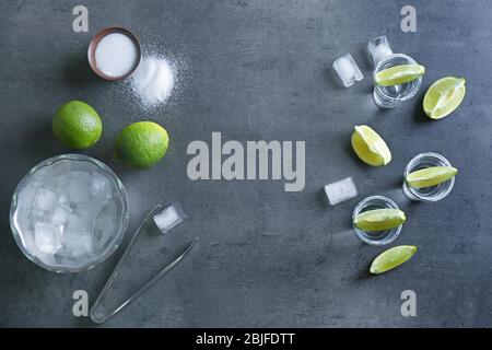 Tequila Shots mit Limettenscheiben und Salz auf dem Tisch Stockfoto