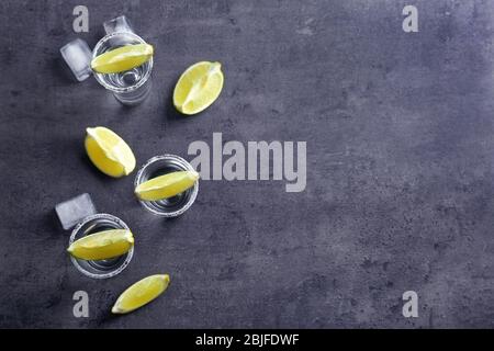 Tequila Shots mit Limettenscheiben und Salz auf dem Tisch Stockfoto