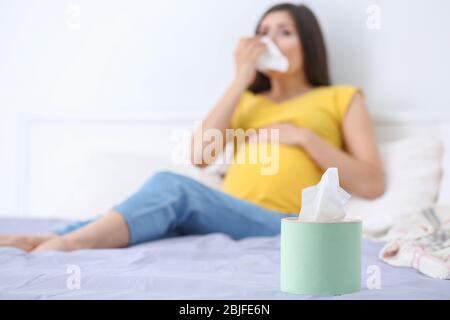 Gewebe und verschwommene Sicht auf kranke schwangere Frau im Bett Stockfoto