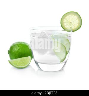 Glas mit Tequila, saftigen Limettenscheiben und Eiswürfeln auf weißem Hintergrund Stockfoto