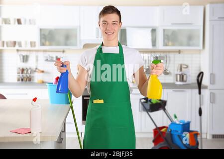 Junge männliche Reiniger bei der Arbeit in der Küche Stockfoto
