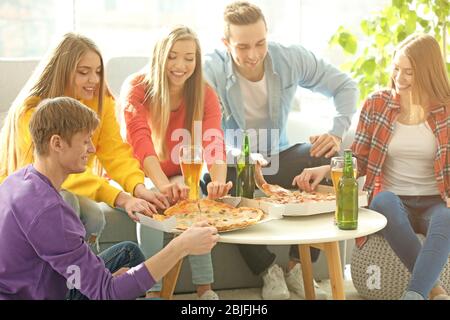 Freunde mit leckeren Pizza und Bier zu Hause Party Stockfoto
