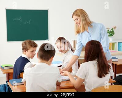 Lehrerinnen und Schülerinnen, die Aufgaben im Klassenzimmer erledigen Stockfoto