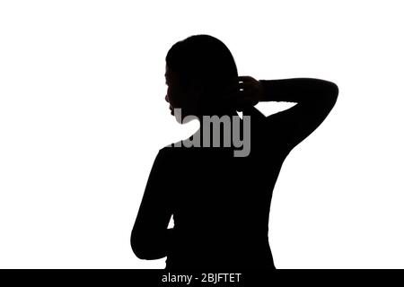 Schwarz hintergrundbeleuchtete Silhouette von Kopf und Schultern einer orientalischen Frau aus der Rückansicht durch Licht umrissen Stockfoto