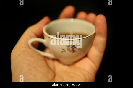 Eine kleine Tasse Kaffee in der Hand Stockfoto