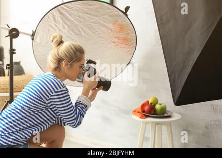 Junge Frau fotografiert Essen in professionellen Fotostudio Stockfoto