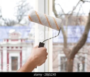 Hand des jungen Mannes, der im Büro Fenster malen will Stockfoto