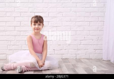 Kleine Ballerina auf dem Boden im Tanzstudio Stockfoto