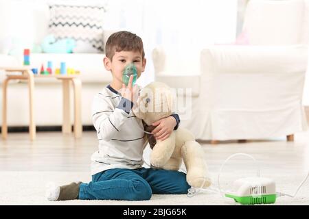 Niedlichen kleinen Jungen mit Vernebler zu Hause. Allergiekonzept Stockfoto