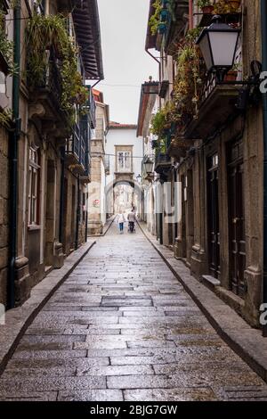 Typische Straßenszene der engen Gasse in der malerischen Stadt Guimares im Norden Portugals Stockfoto