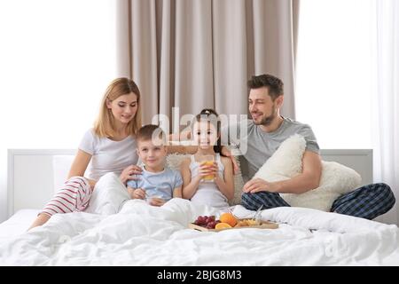 Glückliche Familie mit Frühstück im Bett Stockfoto