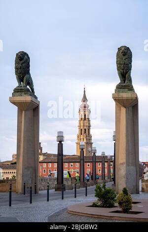 Turm der Kathedrale von Salvador und Bronzestatuen von Löwen am Eingang der Steinbrücke Ponte de Piedra in Zaragoza, Spanien Stockfoto