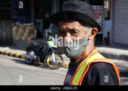 Antipolo City, Philippinen - 28. April 2020: Ein erwachsener philippinischer Mann, der während des Covid 19 Virus ein Tuch oder eine waschbare Gesichtsmaske und einen Hut trägt Stockfoto