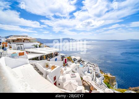 Die weiß getünchten Hügel Stadt Oia, Griechenland, mit Cafés und Hotels mit Blick auf das Ägäische Meer und die Caldera. Stockfoto