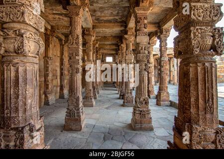 Steinschnitzereien an den Kreuzstegsäulen der Quwwat ul-Islam Moschee im Qutb Minar Komplex, UNESCO-Weltkulturerbe in Delhi, Indien Stockfoto