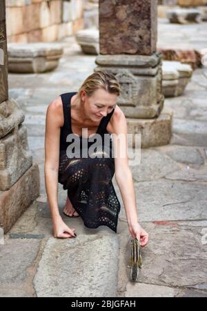 Neu Delhi / Indien - 21. September 2019: Touristenfrau füttert das nördliche Palmenhörnchen (Funambulus pennantii) im Qutb Minar Komplex, UNESCO Welt He Stockfoto