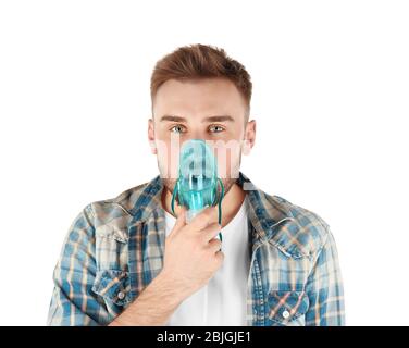 Junger Mann, der Vernebler für Asthma und Atemwegserkrankungen auf weißem Hintergrund verwendet Stockfoto