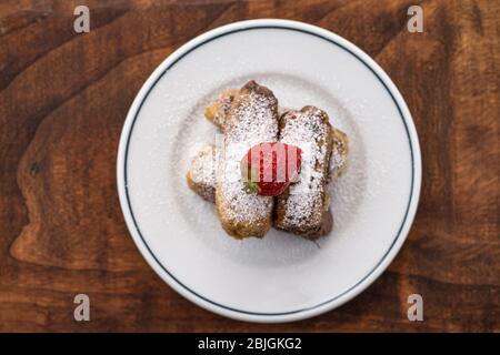 Frisch gebackene Brötchen Brötchen mit Zuckerfüllung auf Pergamentpapier. Draufsicht. Süße hausgemachte Gebäck weihnachtsbacken. Nahaufnahme. Kanelbule.hausgemachte Bäckerei Stockfoto