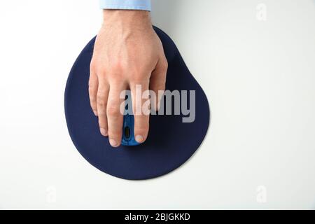 Männliche Hand mit Computermaus und Pad auf weißem Hintergrund Stockfoto