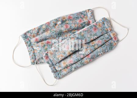 Zwei hausgemachte COVID-19 Gesichtsmasken auf Weiß. Masken zu Hause zu machen hilft, den Mangel an verfügbaren Schutz für die Öffentlichkeit zu lindern. Stockfoto