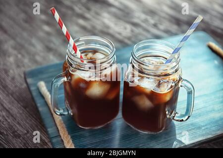 Mason Gläser mit kaltem Brühkaffee auf Holztablett Stockfoto